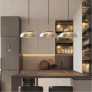Modern kitchen interior with pendant lights, cabinets, and a refrigerator.