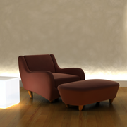 Brown armchair and ottoman on a wooden floor with a neutral wall background